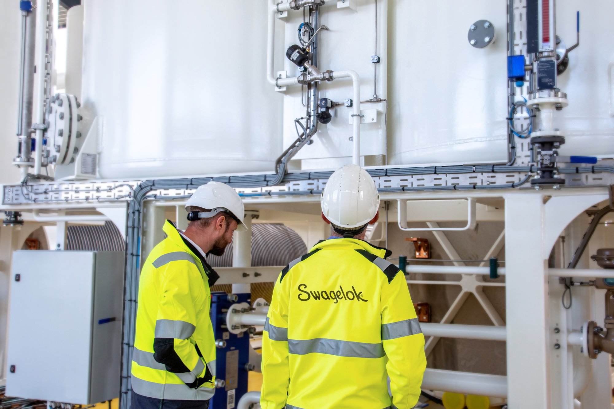 Two engineers wearing yellow Swagelok uniform Two engineers wearing yellow Swagelok uniform